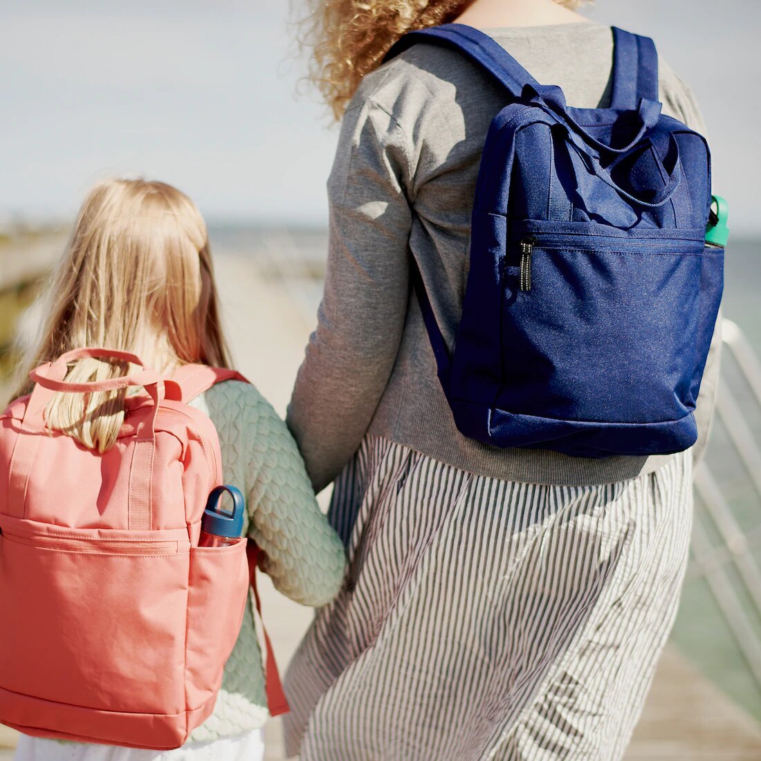 Madre e hija con mochilas andando